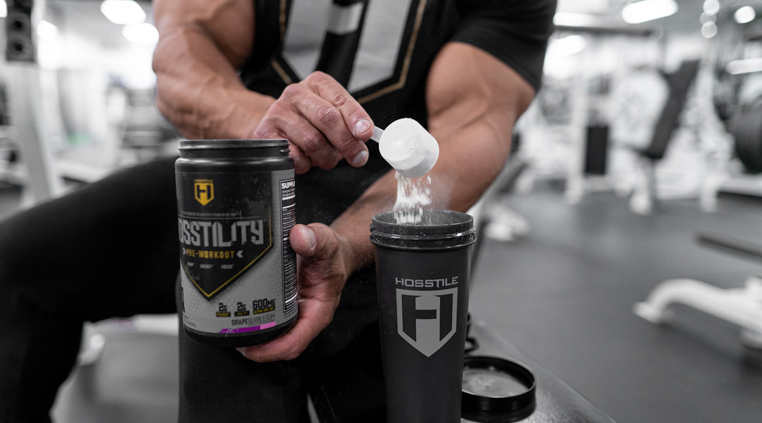 Bodybuilder Fouad Abiad scooping Hosstility pre-workout into a Hosstile shaker cup