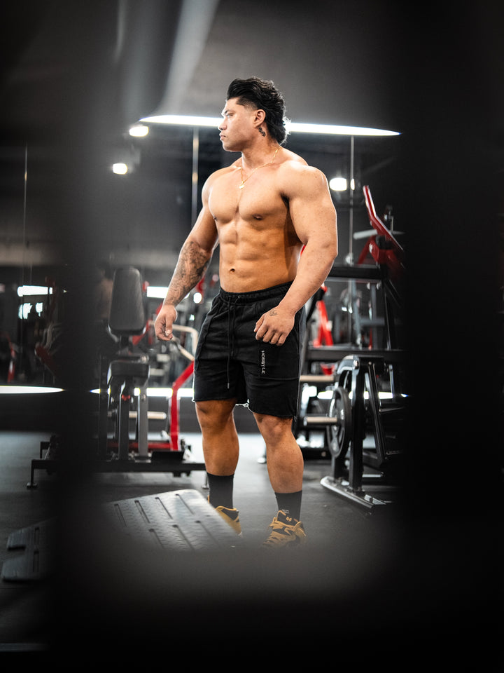 Bodybuilder wearing the Classic Raw shorts#color_black
