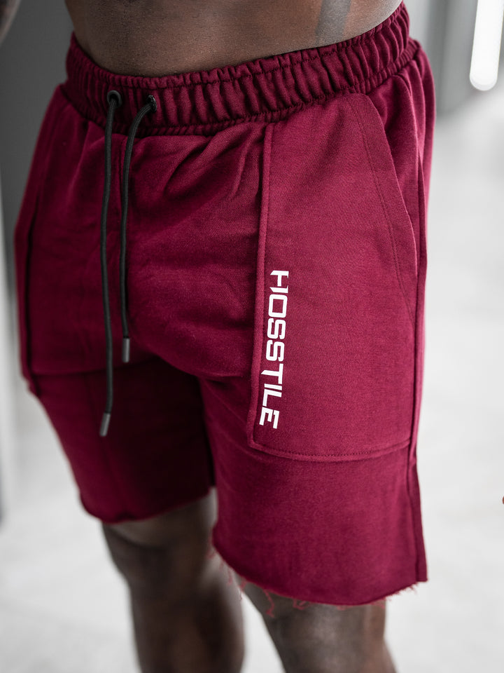 Bodybuilder wearing the Classic Raw shorts#color_cherry