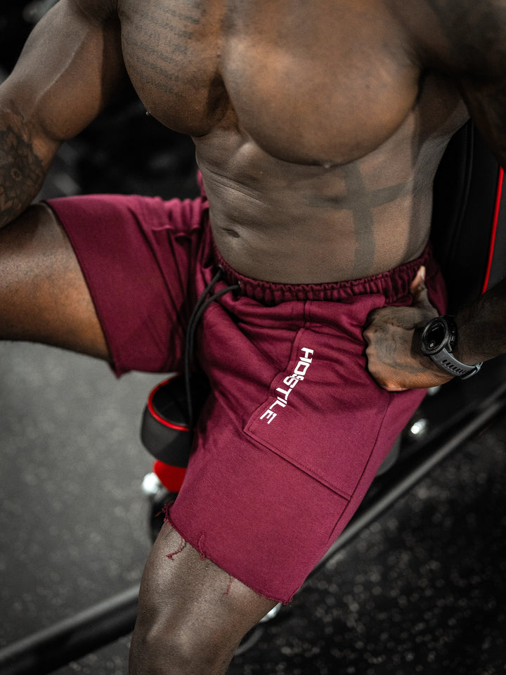 Bodybuilder wearing the Classic Raw shorts#color_cherry