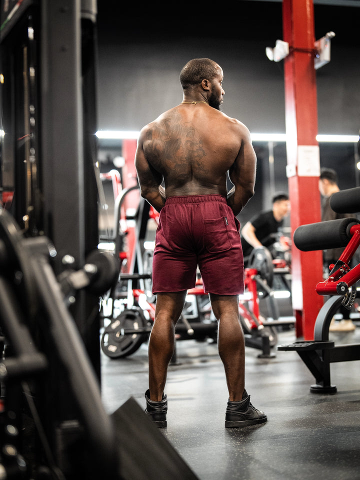 Bodybuilder wearing the Classic Raw shorts#color_cherry