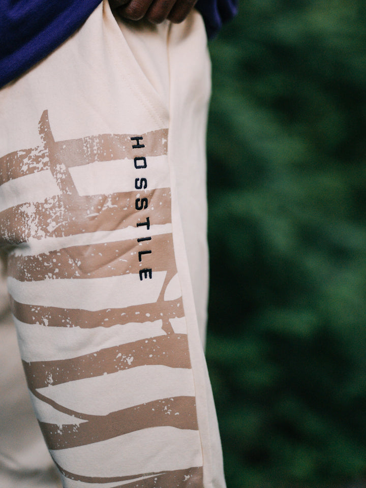 Bodybuilder wearing the Defiant Straight Leg Jogger#color_off-white