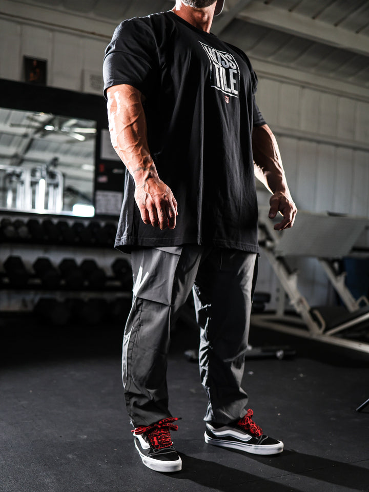 Bodybuilder wearing Gym Cargo Pants#color_charcoal