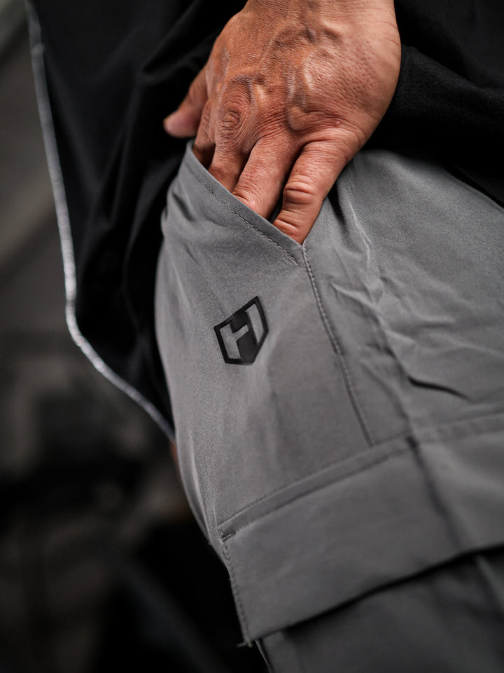 Bodybuilder wearing Gym Cargo Pants#color_charcoal