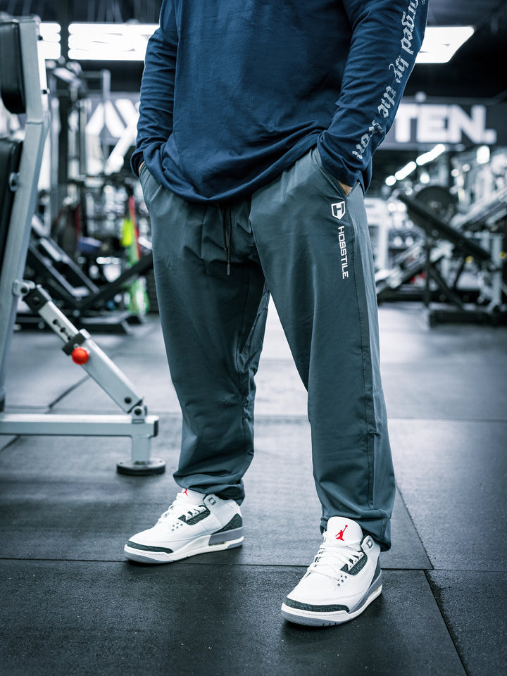 IFBB Pro Bodybuilder Martin Fitzwater wearing a long-sleeve shirt and dark grey pants in a gym setting#color_dark-grey