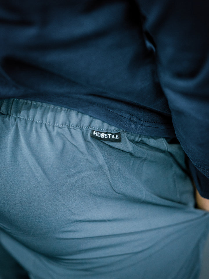 IFBB Pro Bodybuilder Martin Fitzwater wearing a long-sleeve shirt and dark grey pants in a gym setting#color_dark-grey