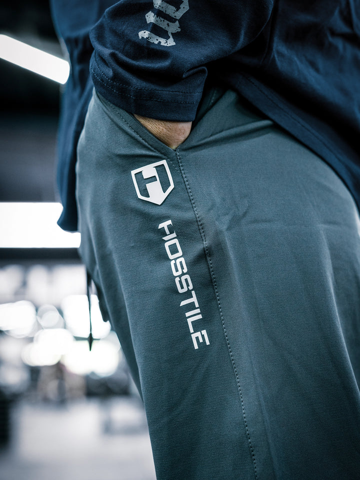 IFBB Pro Bodybuilder Martin Fitzwater wearing a long-sleeve shirt and dark grey pants in a gym setting#color_dark-grey