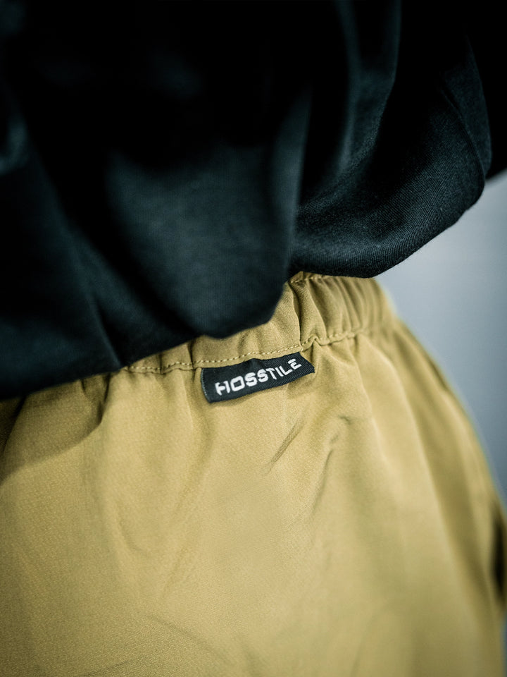 IFBB Pro Bodybuilder Martin Fitzwater wearing a long-sleeve shirt and khaki pants in a gym setting#color_khaki