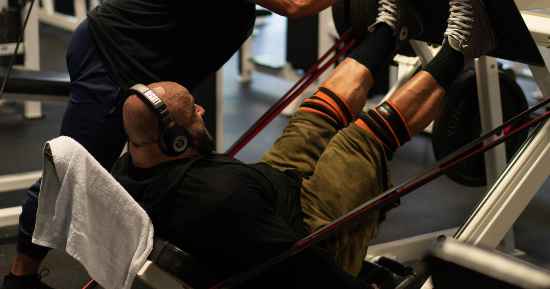 Bodybuilder Fouad Abiad doing leg presses on the leg press machine with weights and with resistance bands