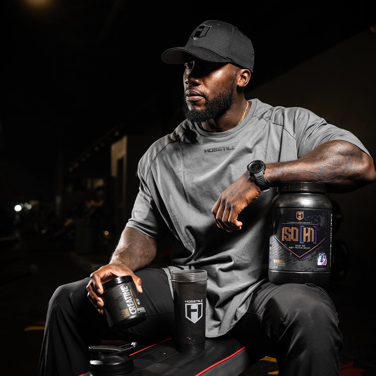 bodybuilder holding protein and shaker cup in a gym setting