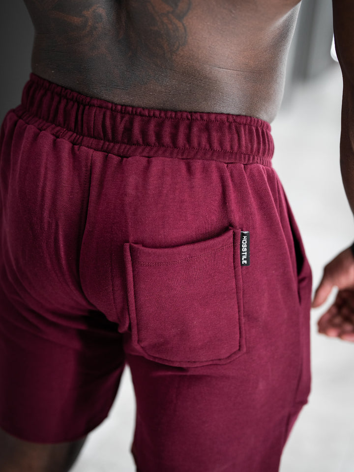 Bodybuilder wearing the Classic Raw shorts#color-cherry