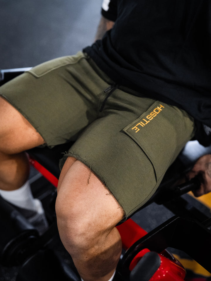 Bodybuilder wearing the Classic Raw shorts#color-military-green