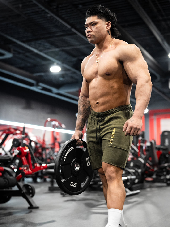 Bodybuilder wearing the Classic Raw shorts#color-military-green