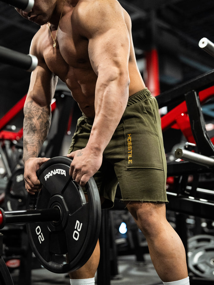 Bodybuilder wearing the Classic Raw shorts#color-military-green