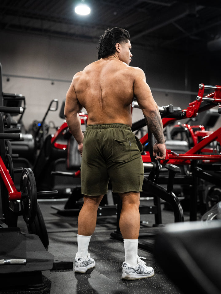 Bodybuilder wearing the Classic Raw shorts#color-military-green