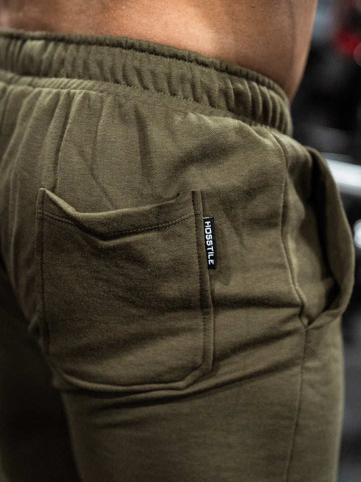 Bodybuilder wearing the Classic Raw shorts#color-military-green