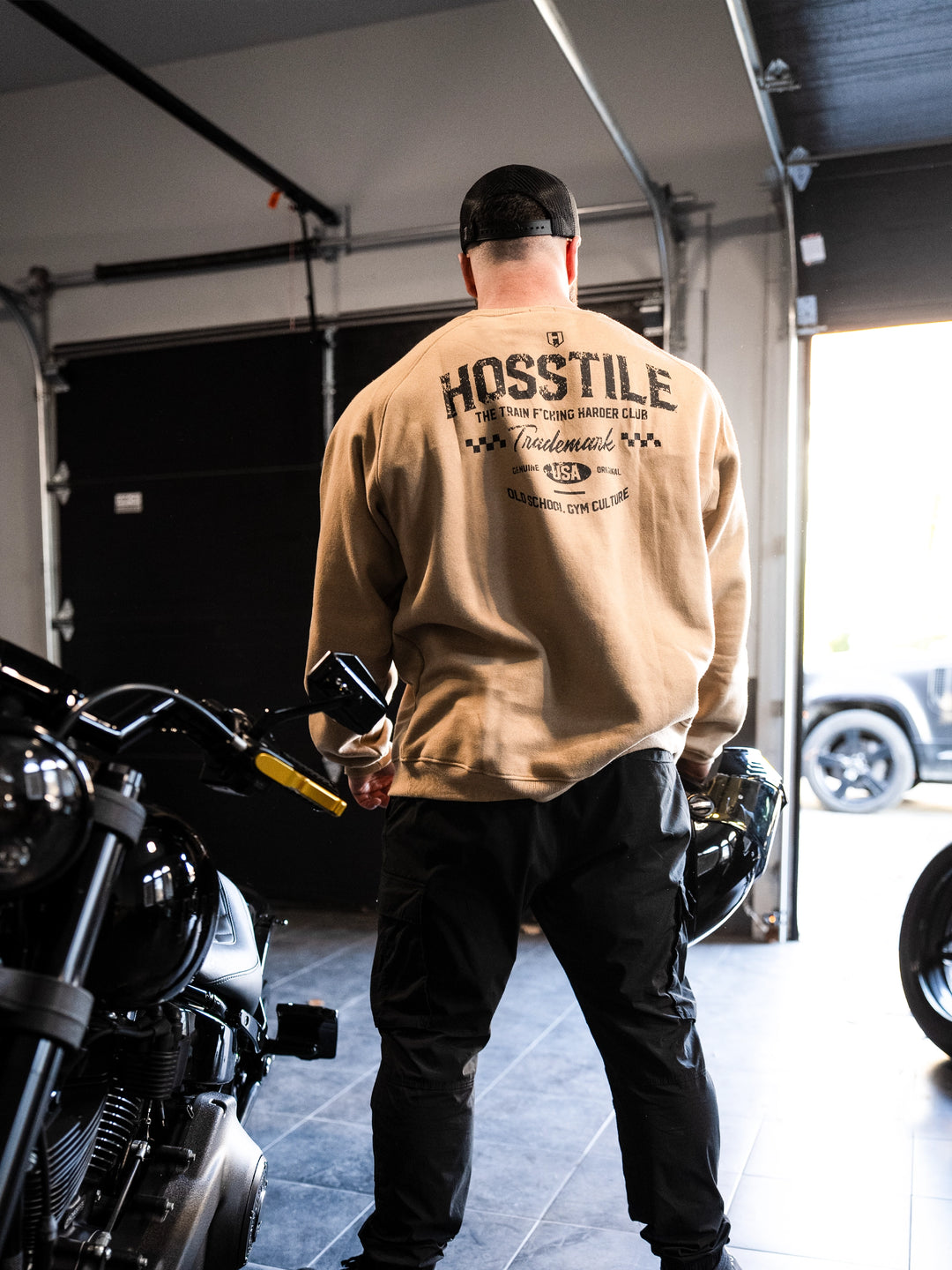 Bodybuilder wearing the Hosstile Club Crew Sweatshirt#color_desert