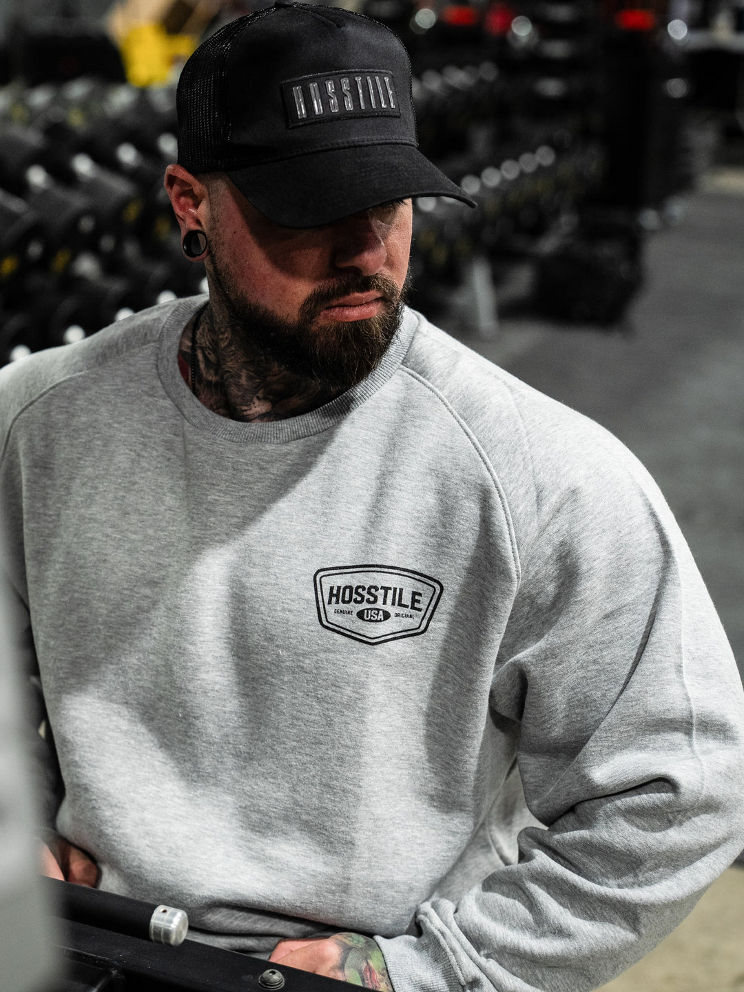 Bodybuilder wearing the Hosstile Club Crew Sweatshirt#color_heather-cement