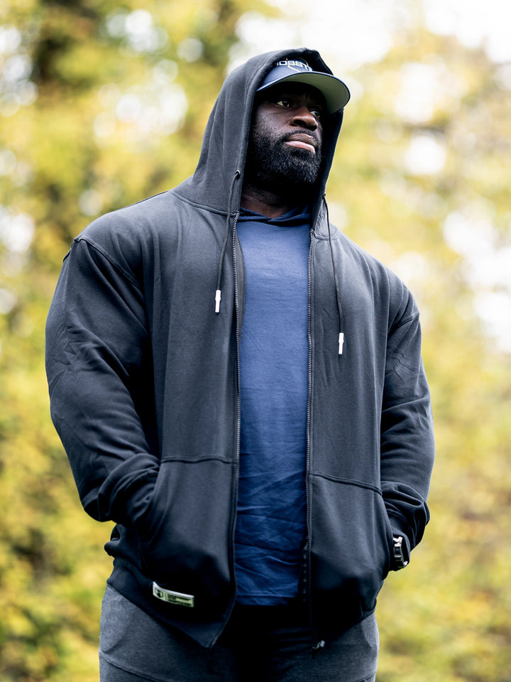 Bodybuilder Samson Dauda wearing the Culture Zip-Up Hoodie#color_black