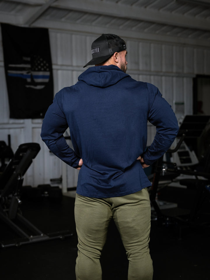 Bodybuilder wearing a lightweight pullover hoodie t-shirt in the gym#color_navy