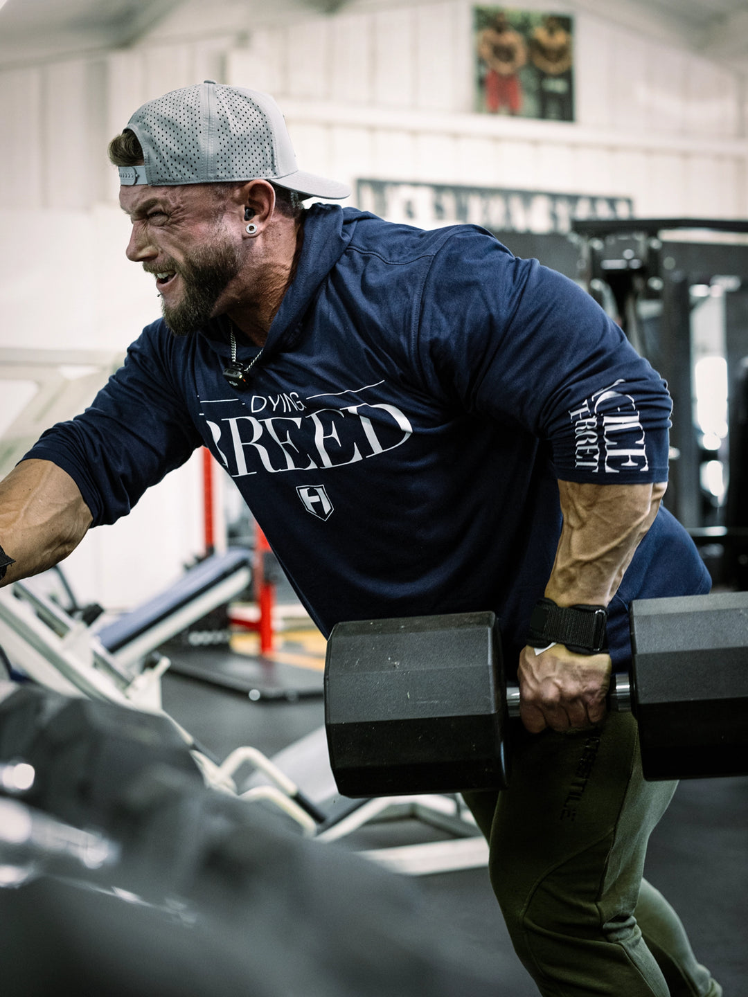 Bodybuilder wearing a lightweight pullover hoodie t-shirt in the gym#color_navy