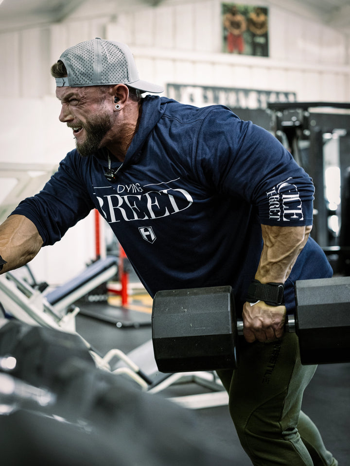 Bodybuilder wearing a lightweight pullover hoodie t-shirt in the gym#color_navy