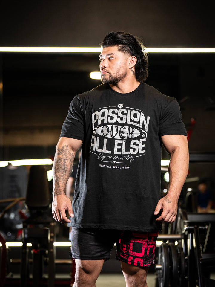 Man wearing a black t-shirt with text in an indoor setting#color_black