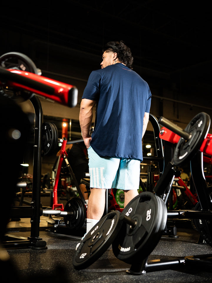 Person in a gym setting with weightlifting equipment#color_navy