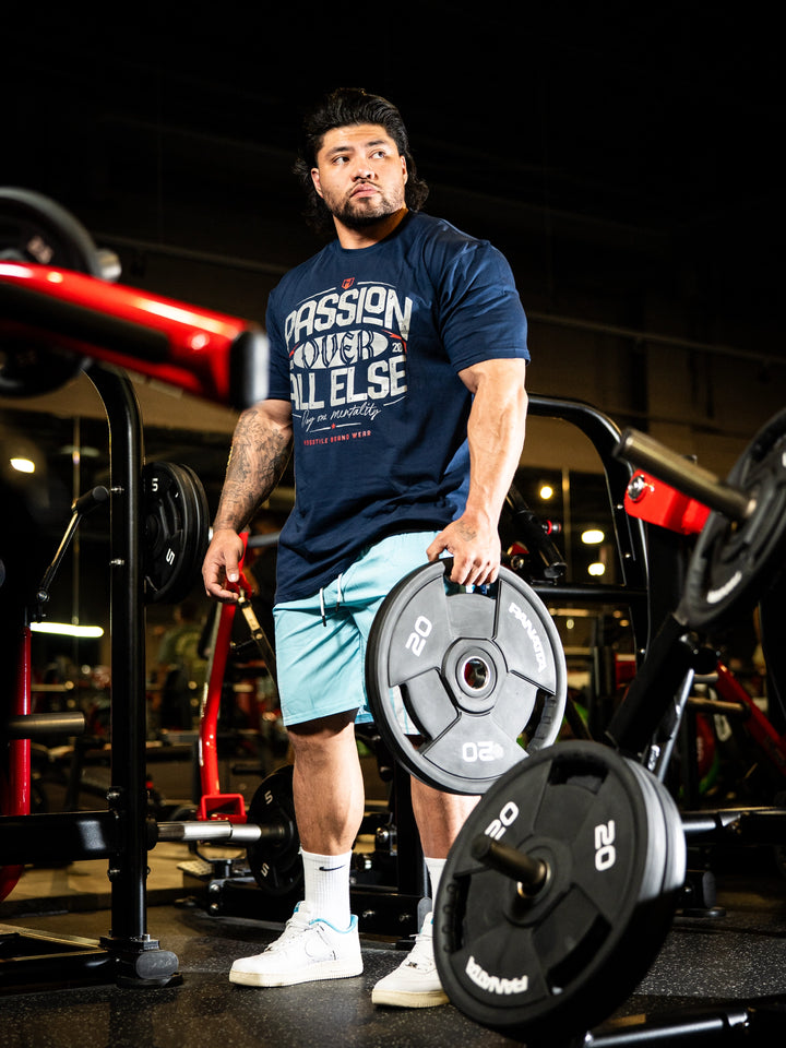 Man holding weight plates in a gym setting#color_navy