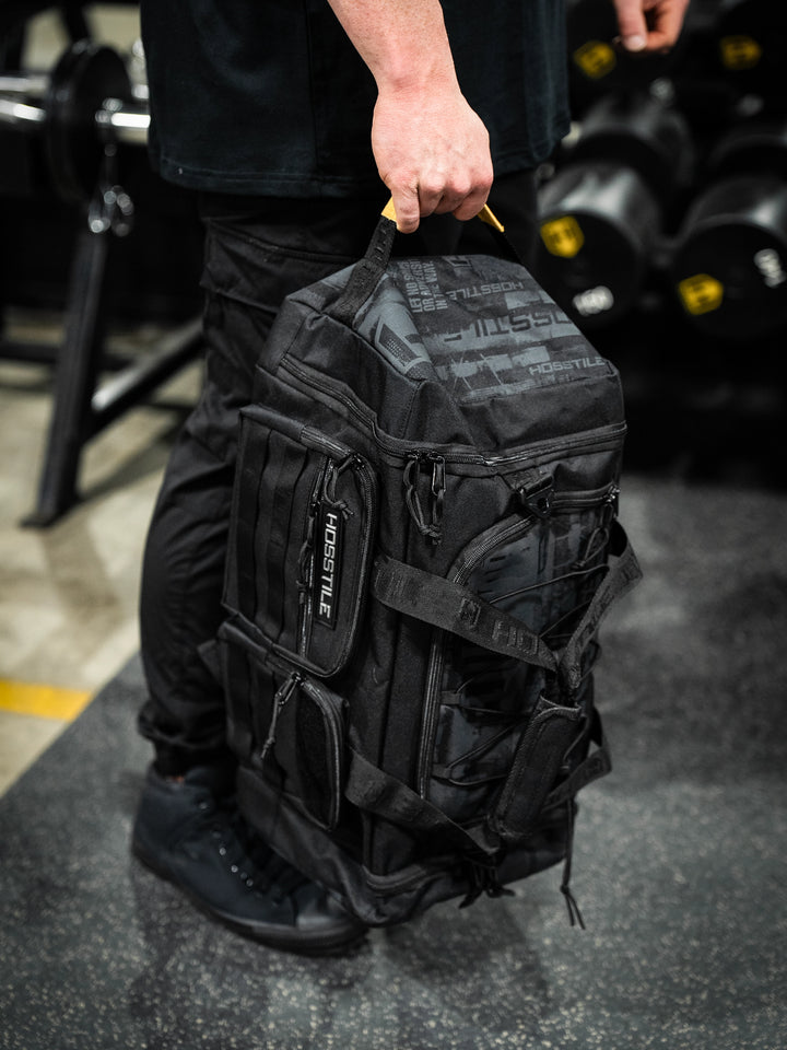 bodybuilder carrying the Hosstile Duffel Backpack in the gym