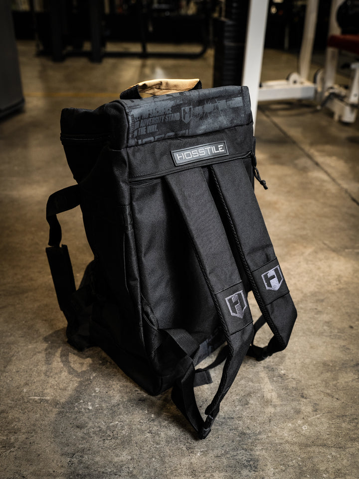 bodybuilder carrying the Hosstile Duffel Backpack in the gym