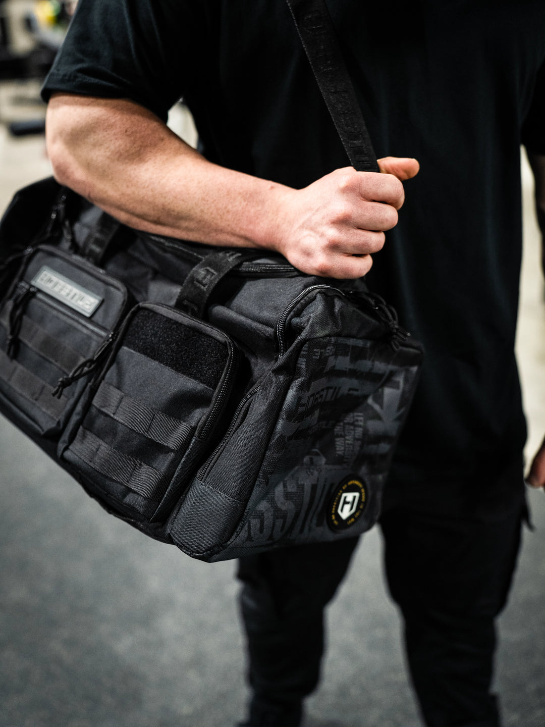 bodybuilder carrying the Hosstile Duffel Backpack in the gym
