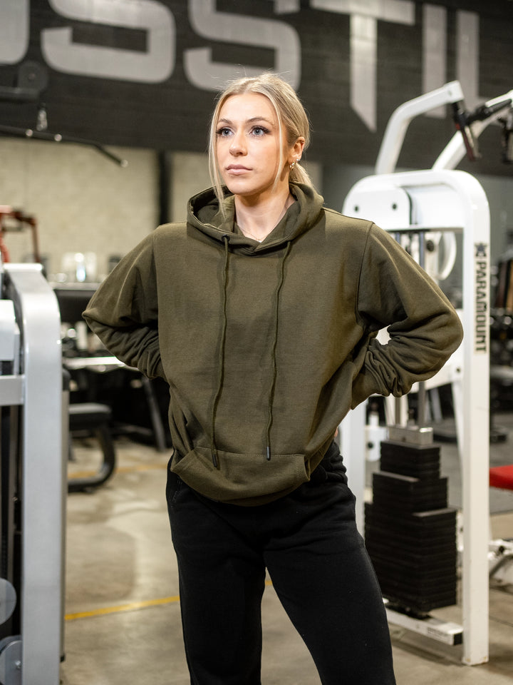 Fitness model wearing Ethos lightweight pullover hoodie#color_dark-moss