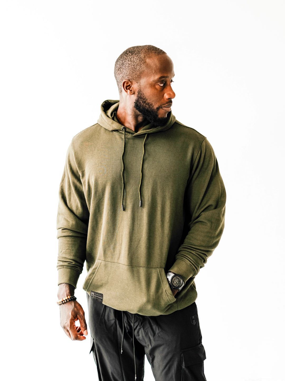 Bodybuilder wearing Ethos lightweight pullover hoodie#color_dark-moss