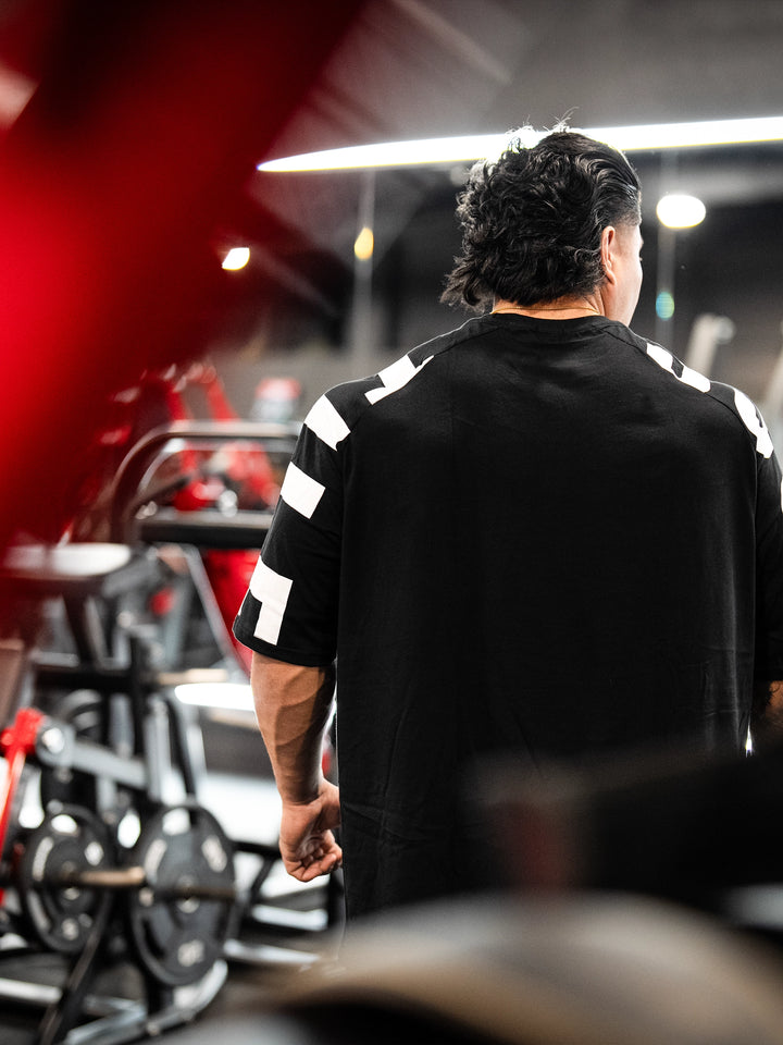 Bodybuilder wearing the Expansion Oversized Tee#color-black