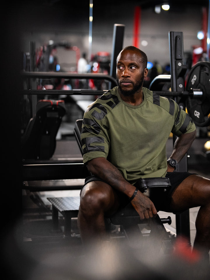 Bodybuilder wearing the Expansion Oversized Tee#color-military-green