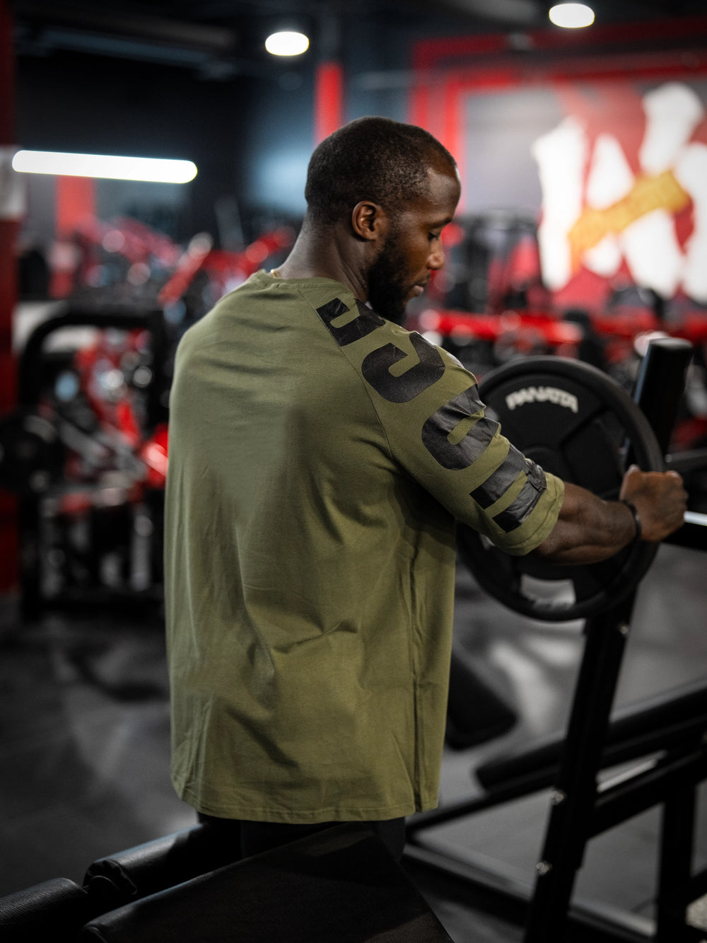 Bodybuilder wearing the Expansion Oversized Tee#color-military-green