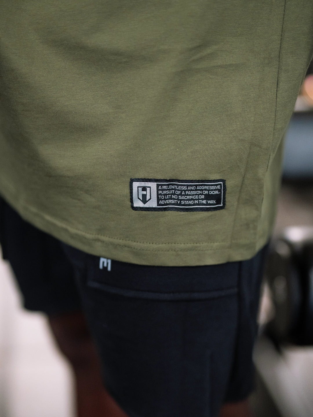 Bodybuilder wearing the Expansion Oversized Tee#color-military-green