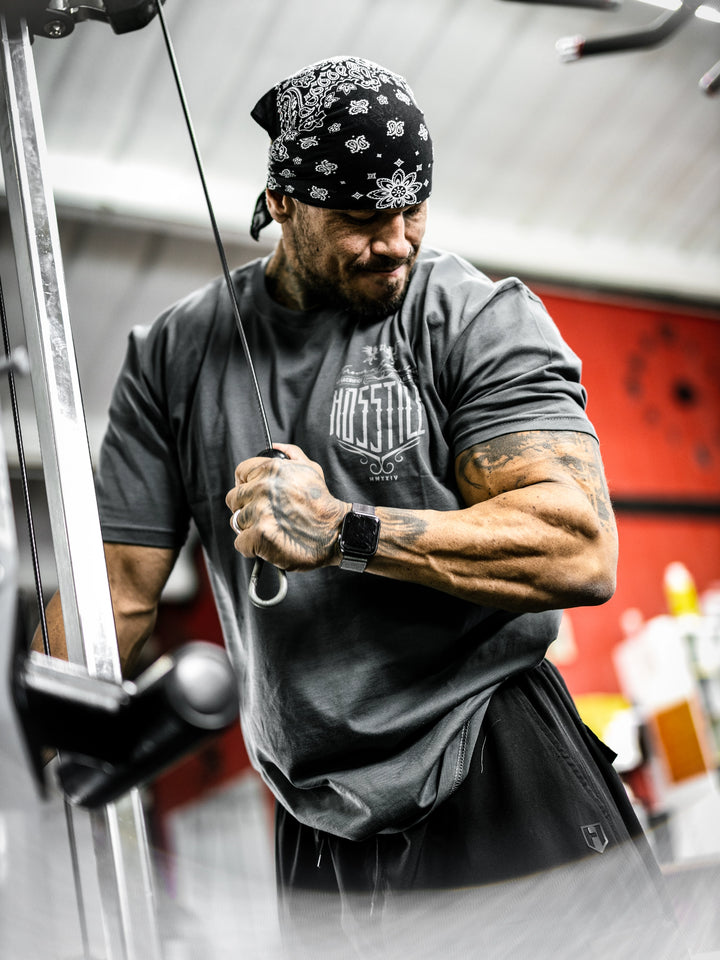 Bodybuilder Ben Chow in a gym wearing a t-shirt with text and graphics.#color_dark-grey
