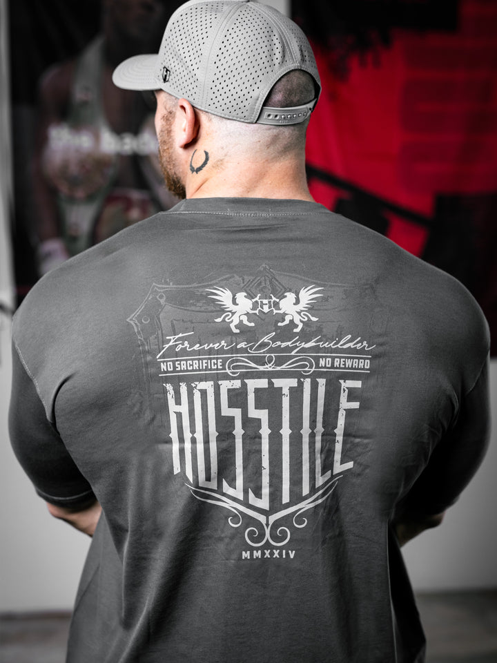 Bodybuilder Martin Fitzwater standing in a gym wearing a t-shirt with text and graphics.#color_dark-grey
