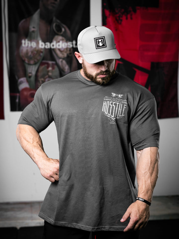 Bodybuilder Martin Fitzwater standing in a gym wearing a t-shirt with text and graphics.#color_dark-grey