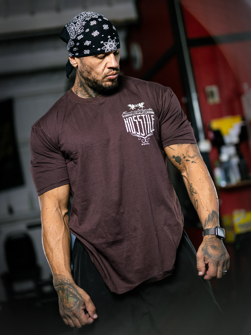 Bodybuilder Ben Chow standing in a gym wearing a t-shirt with text and graphics.#color_mahogany