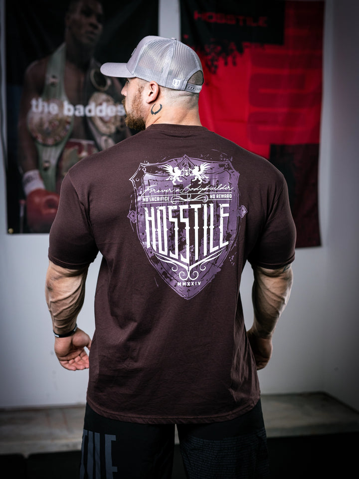 Bodybuilder Martin Fitzwater standing in a gym wearing a t-shirt with text and graphics.#color_mahogany