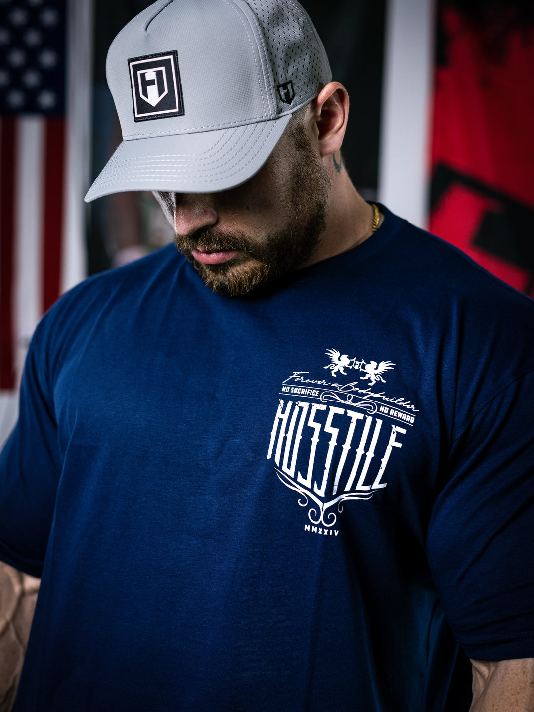 Bodybuilder Martin Fitzwater standing in a gym wearing a t-shirt with text and graphics.#color_navy