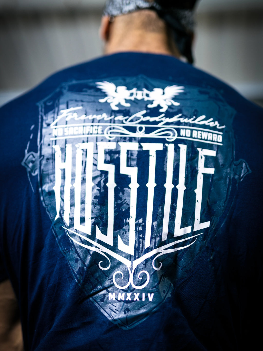 Bodybuilder Ben Chow standing in a gym wearing a t-shirt with text and graphics.#color_navy