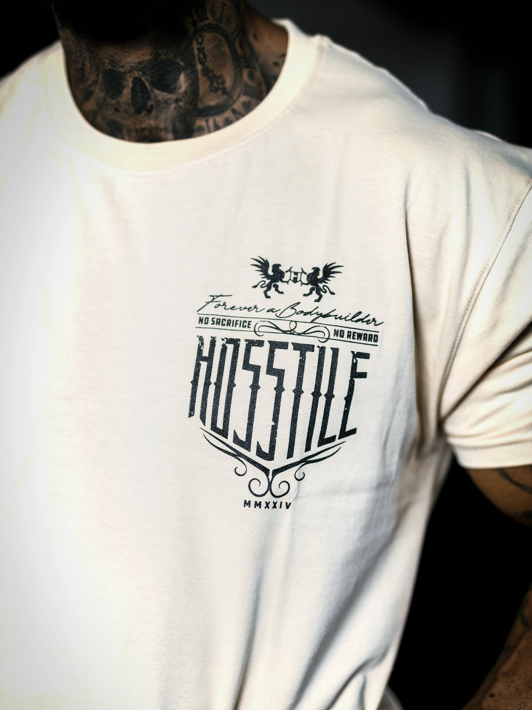 Bodybuilder Ben Chow standing in a gym wearing a t-shirt with text and graphics.#color_off-white