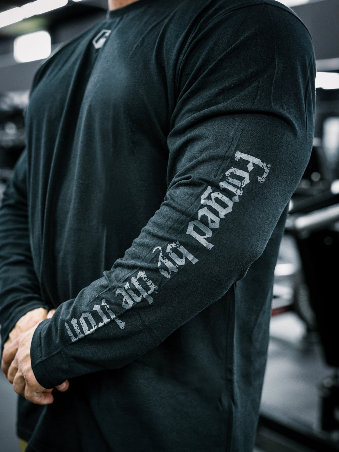 IFBB Pro Bodybuilder Martin Fitzwater wearing a black long-sleeve shirt with text in a gym setting#color_black