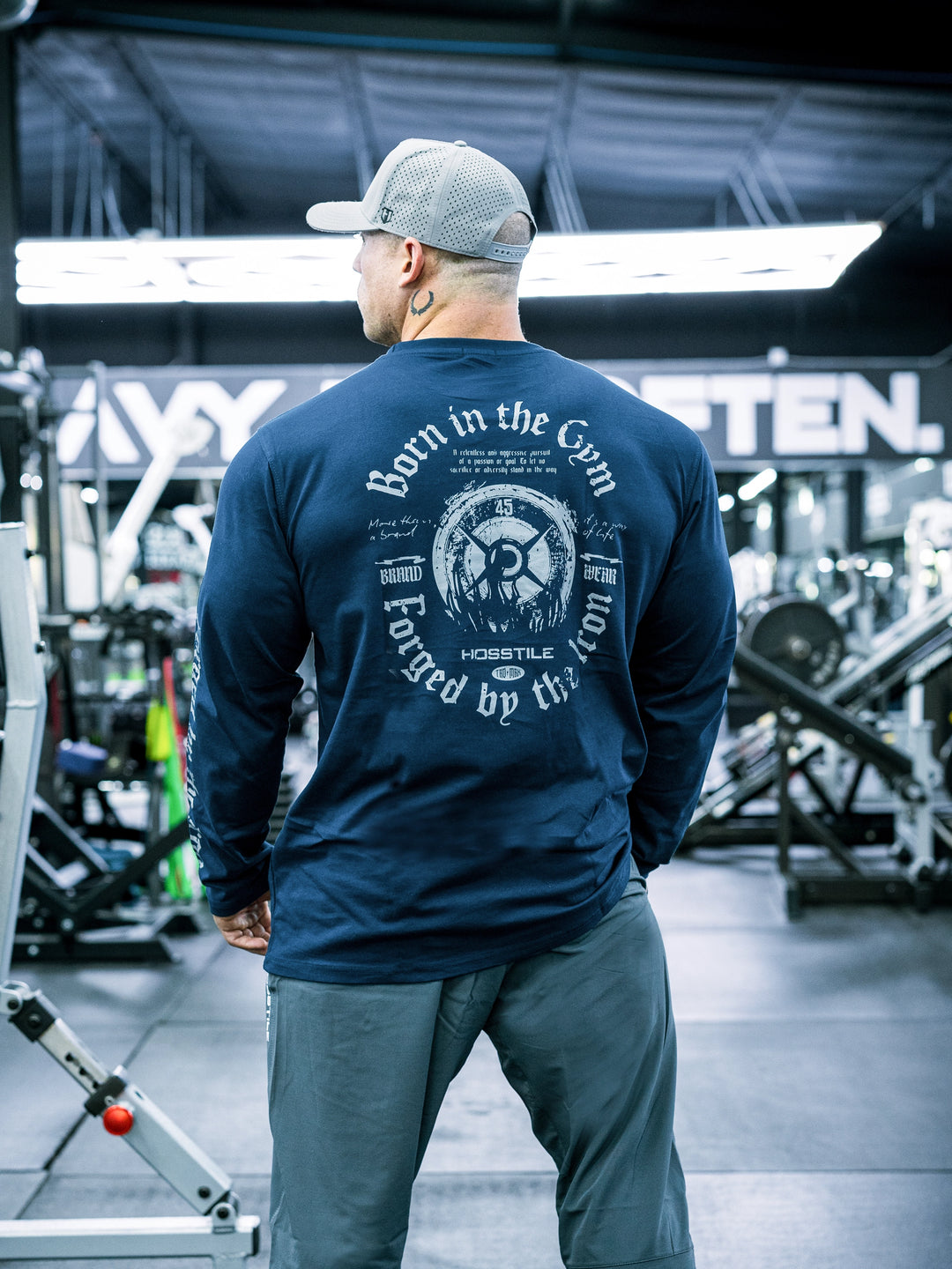 IFBB Pro Bodybuilder Martin Fitzwater wearing a black long-sleeve shirt with text in a gym setting#color_navy