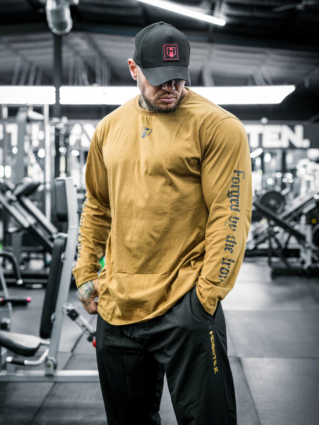 Bodybuilder Ben Chow wearing a black long-sleeve shirt with text in a gym setting#color_texas-clay