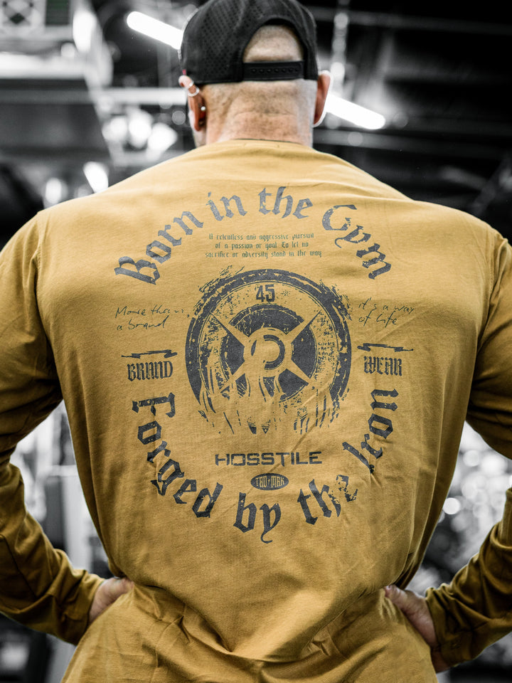 Bodybuilder Ben Chow wearing a black long-sleeve shirt with text in a gym setting#color_texas-clay